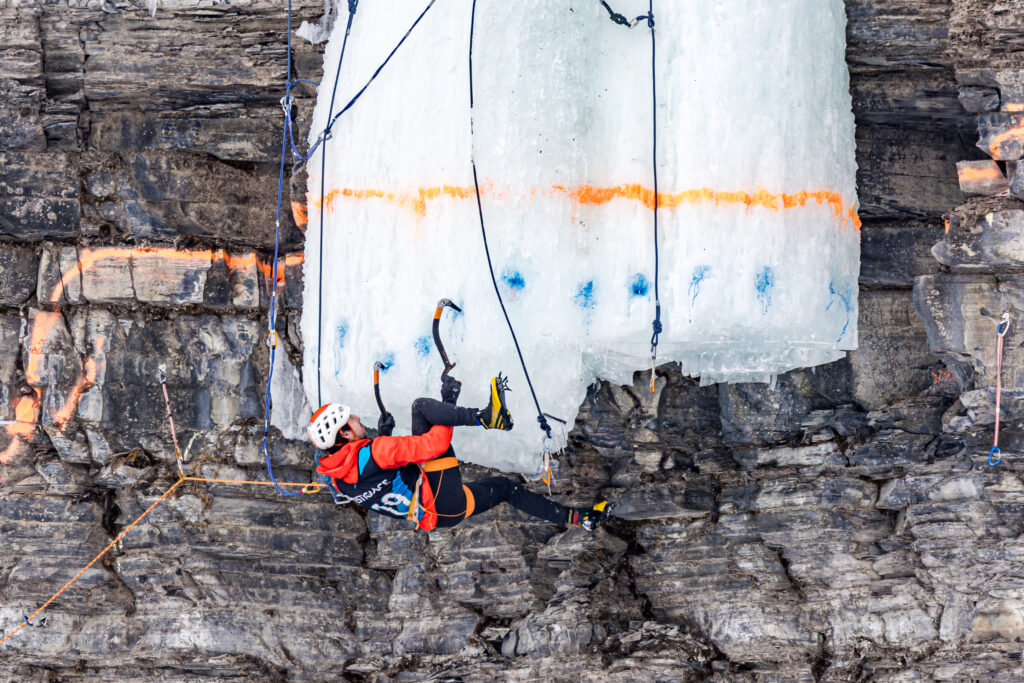 Le grimpeur Jerome St Michel suspendu en position horizontale lors de la competition de difficulte du Festiglace 2025.